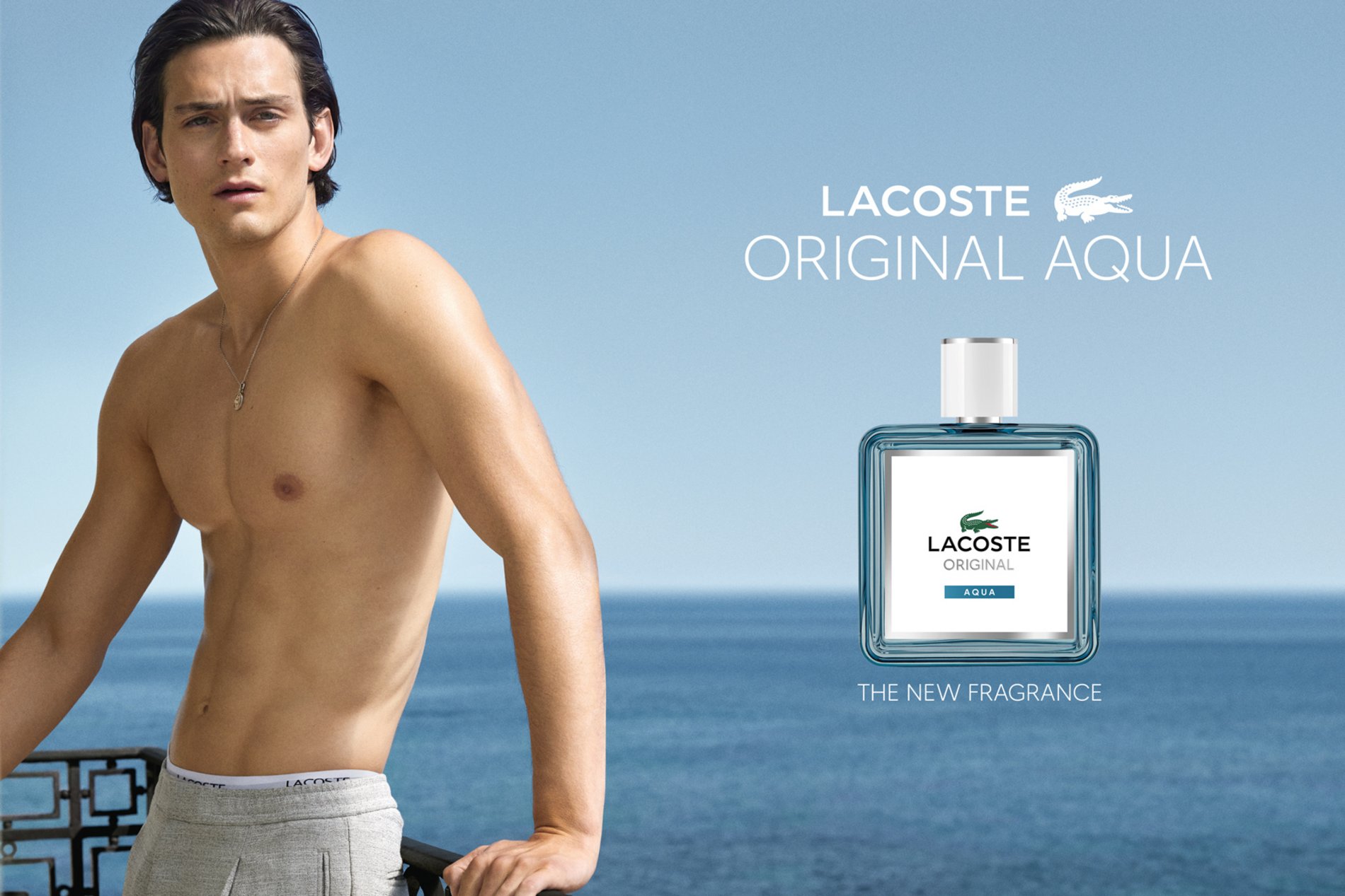 Männliches Model am Meer neben Lacoste Original Aqua Eau de Toilette Flakon, frischer aquatischer Herrenduft mit maritimer Ausstrahlung