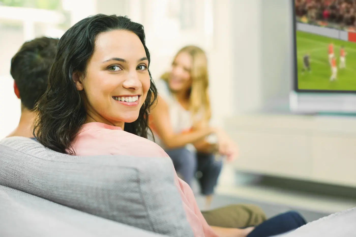 Frau auf Sofa beim Fußballgucken