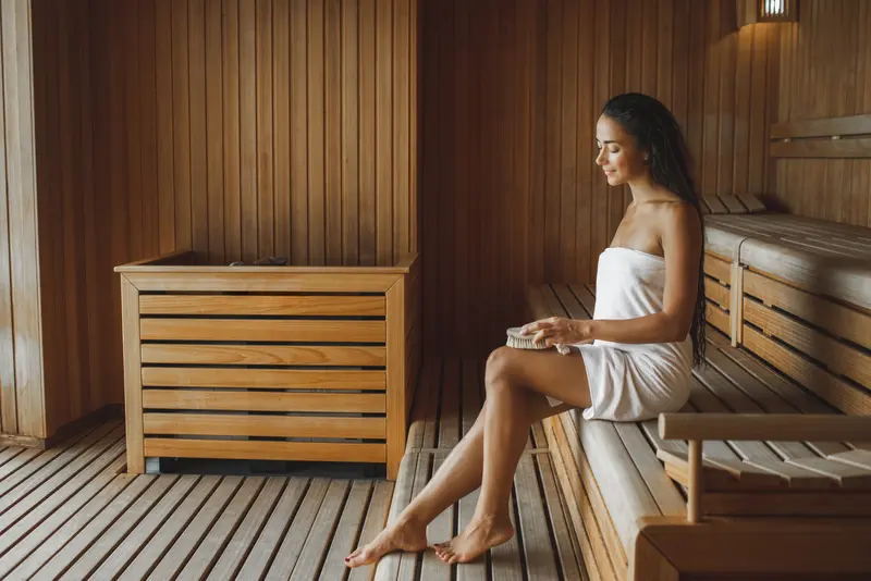 Eine Frau in der Sauna mit Handtuch