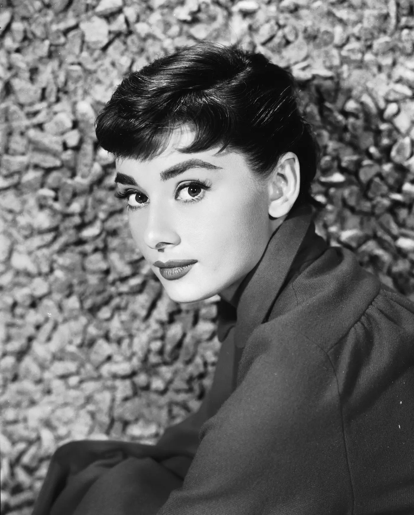 Portrait von Audrey Hepburn vor einer Steinmauer