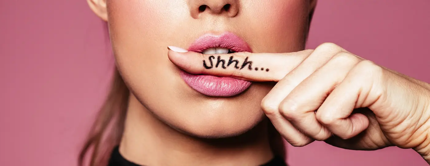 Frau mit Shhh Zeichen auf dem Finger