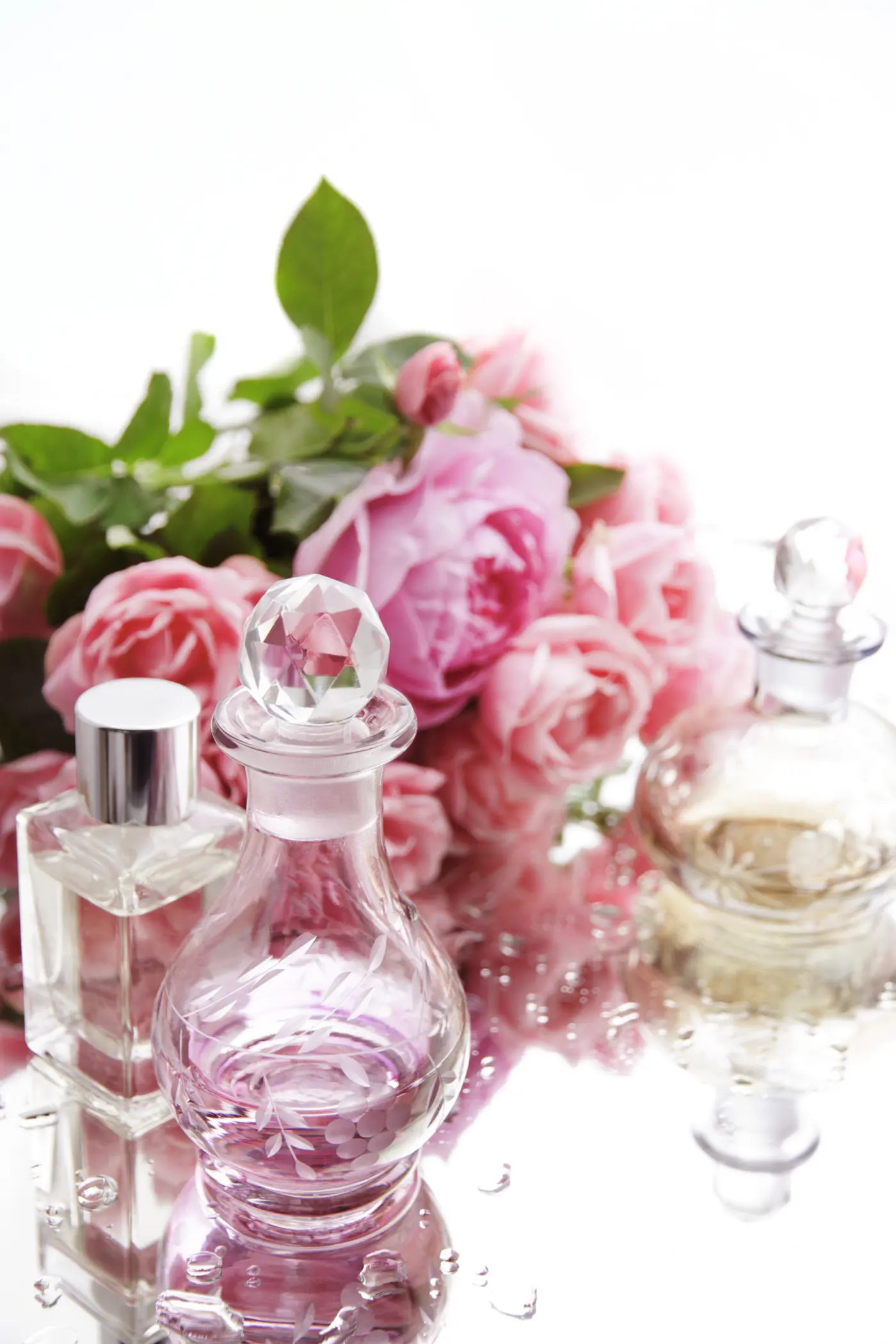 Parfumflaschen mit rosafarbenen Rosen
