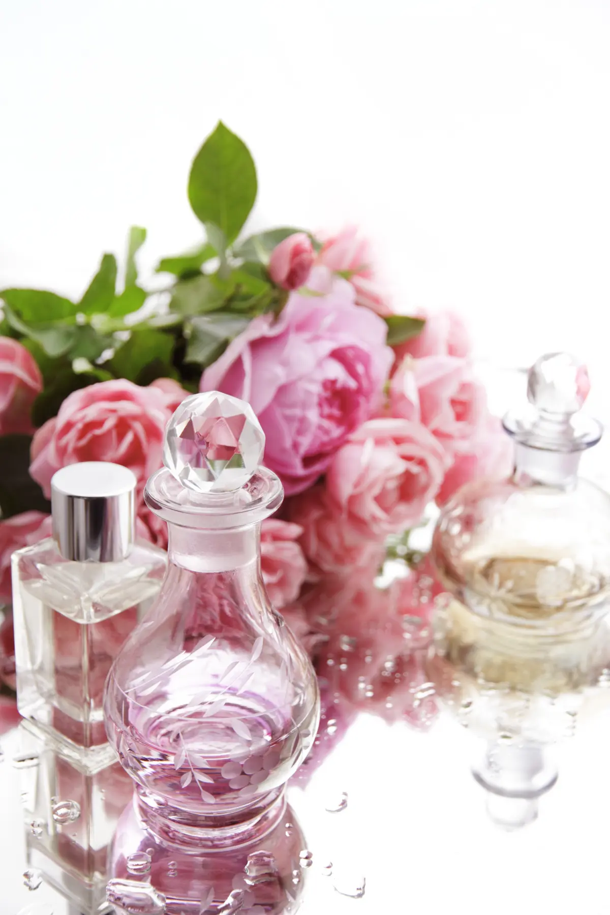 Parfumflaschen mit rosafarbenen Rosen