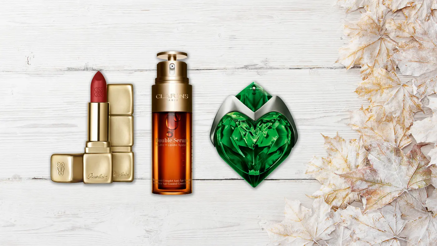 Holzhintergrund mit Makeup und Parfum Flacon im Vordergrund