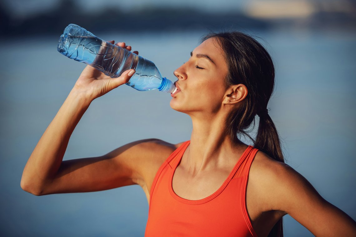 Frau die Wasser trinkt aus einer Flasche Frau die Wasser trinkt aus einer Flasche
