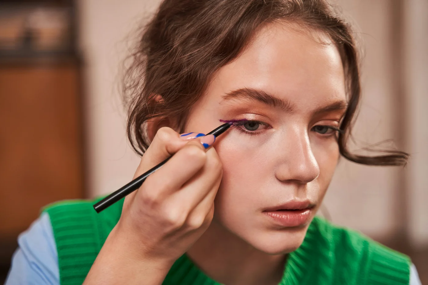 Frau zieht sich einen Lidstrich