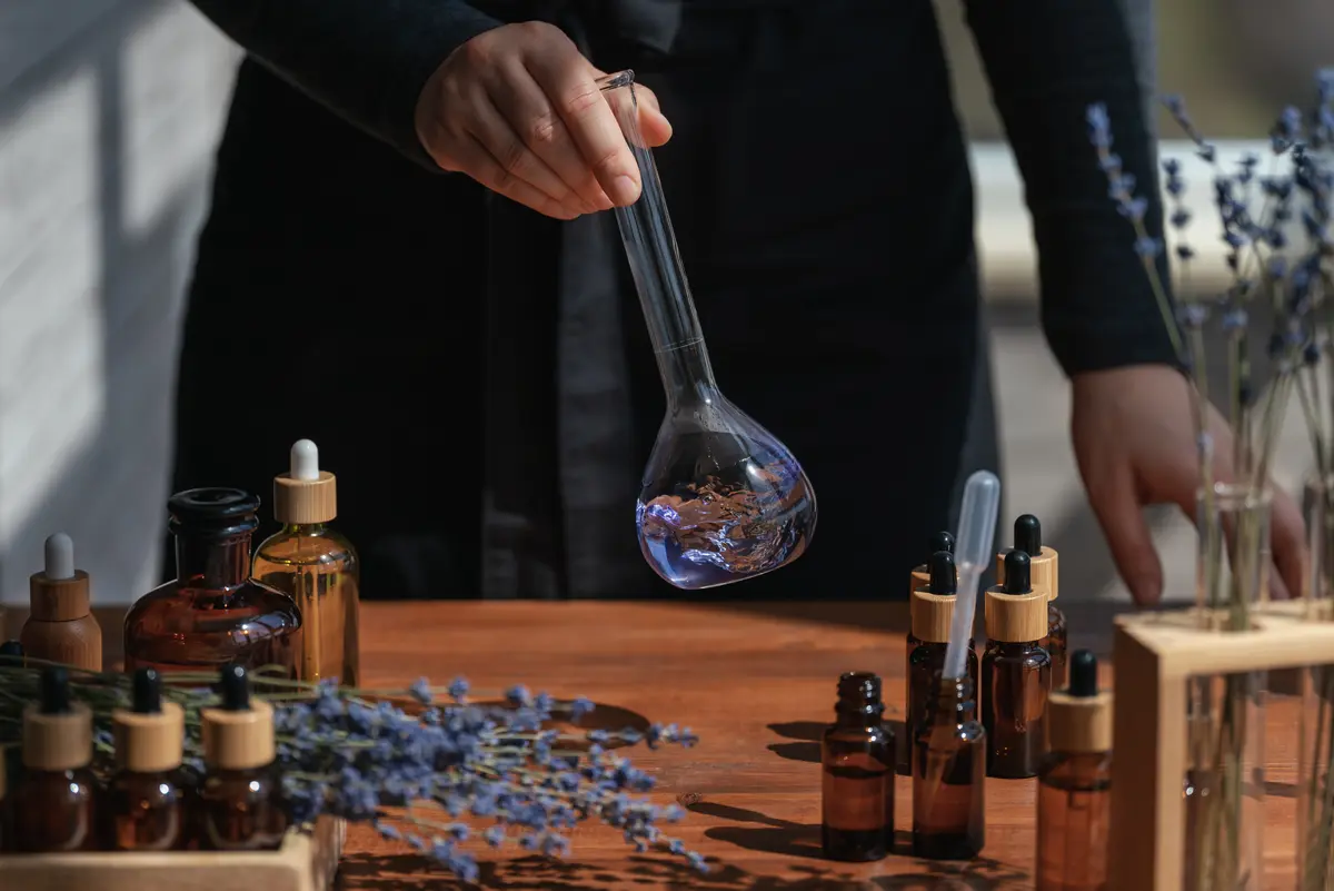 Frau schwenkt getrocknete Blüten in einem Flakon