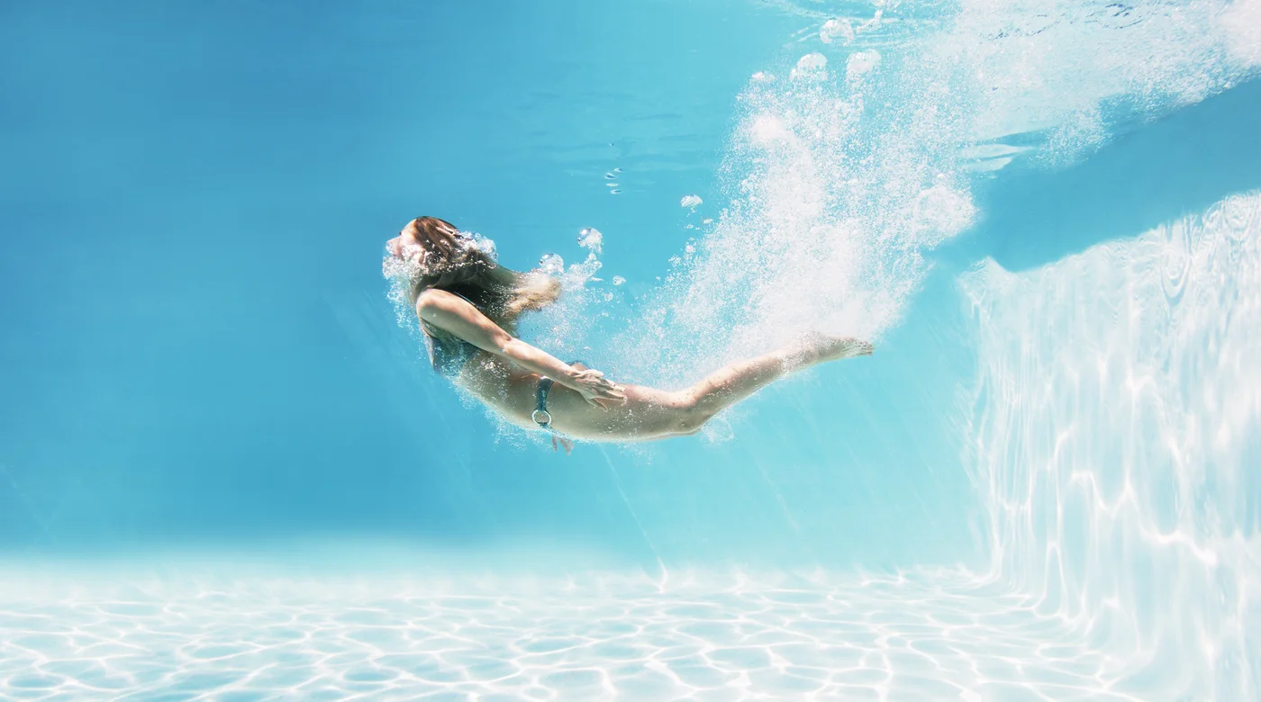 Junge Frau schwimmt unter Wasser
