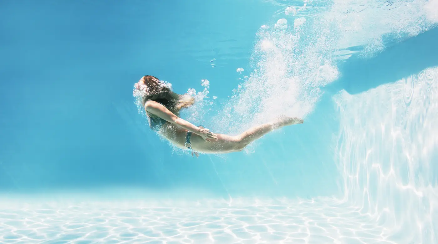 Junge Frau schwimmt unter Wasser