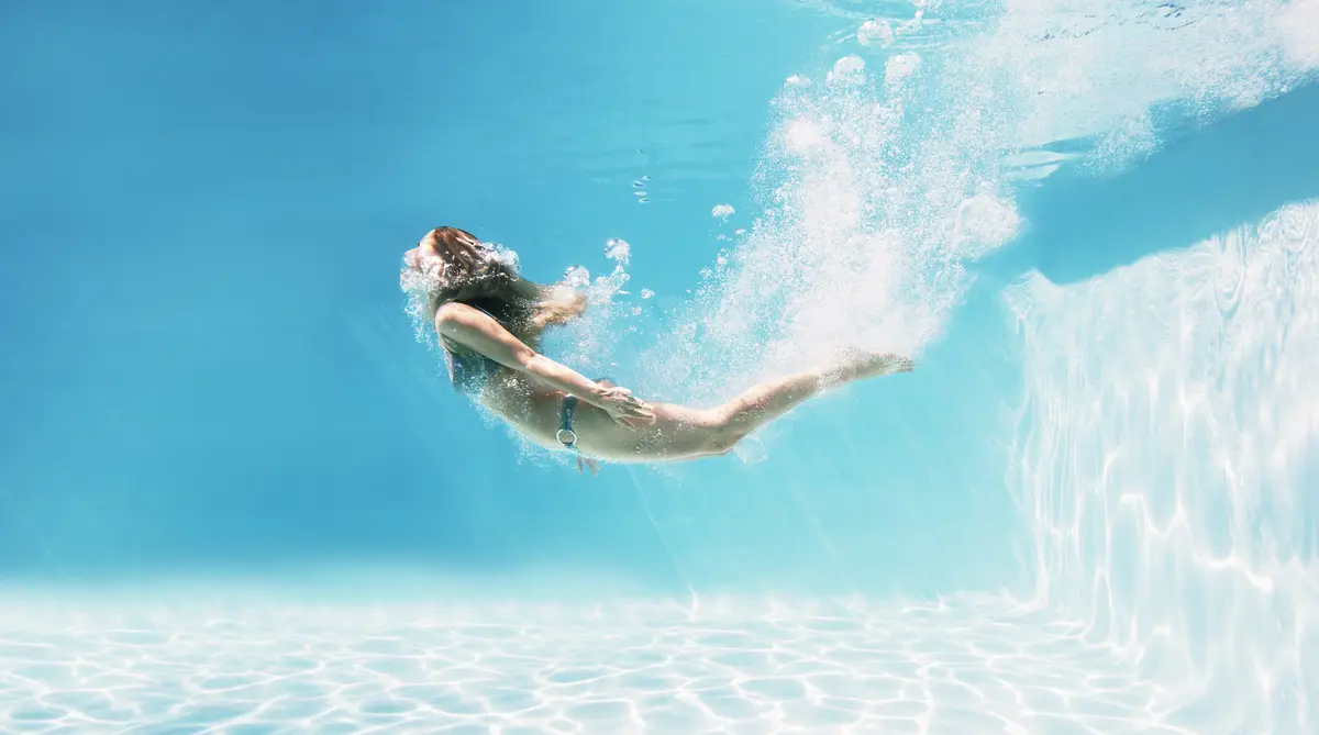 Junge Frau schwimmt unter Wasser