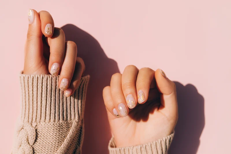 Hände einer jungen Frau mit Glitzernagellack
