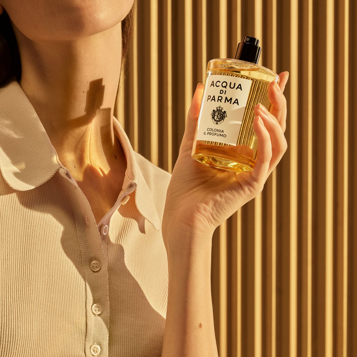 Nahaufnahme auf Frau, die den Flakon von Colonia Il Profumo (Acqua di Parma) in der Hand hält