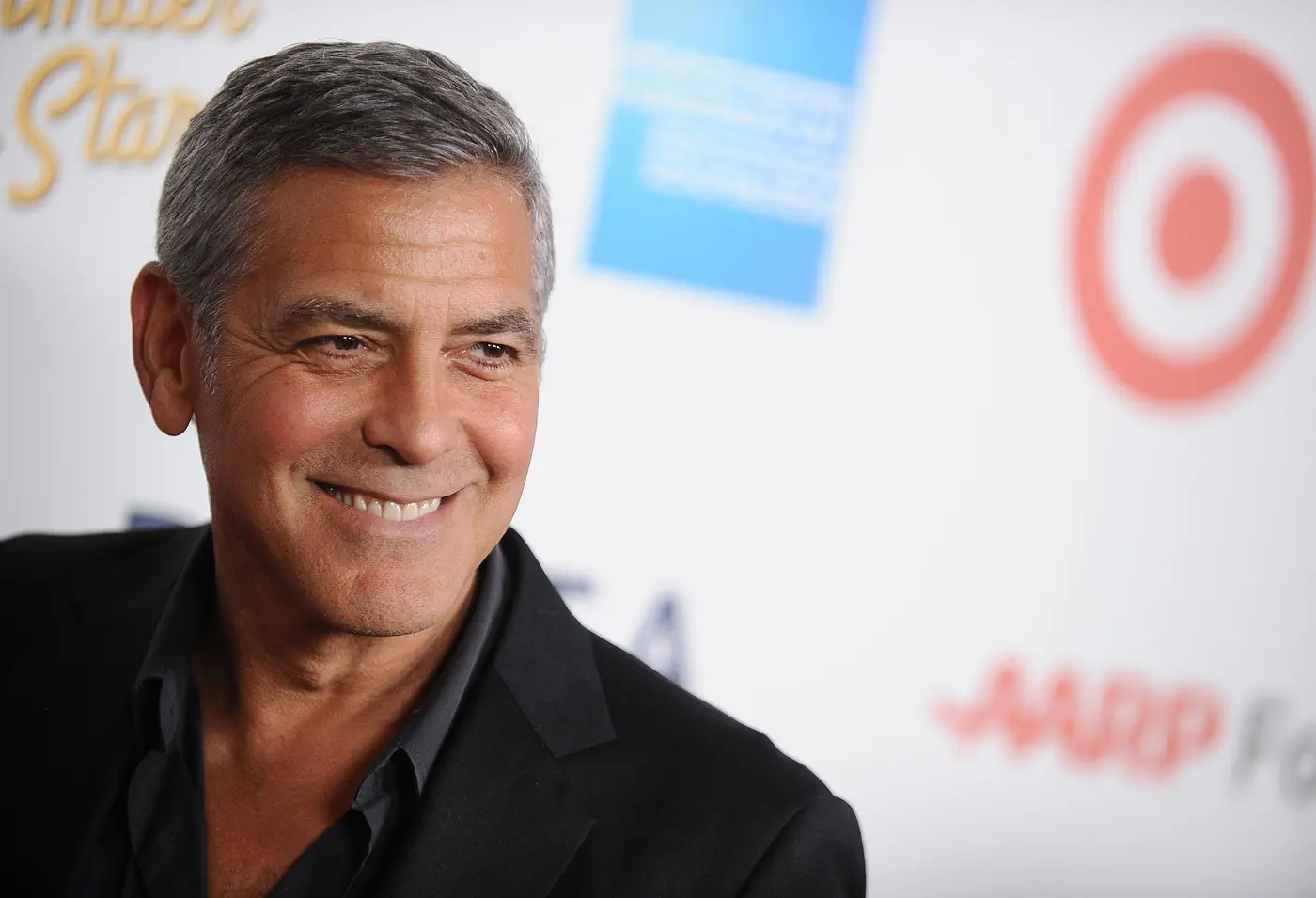 Gut rasierter George Clooney lächt in die Kameras