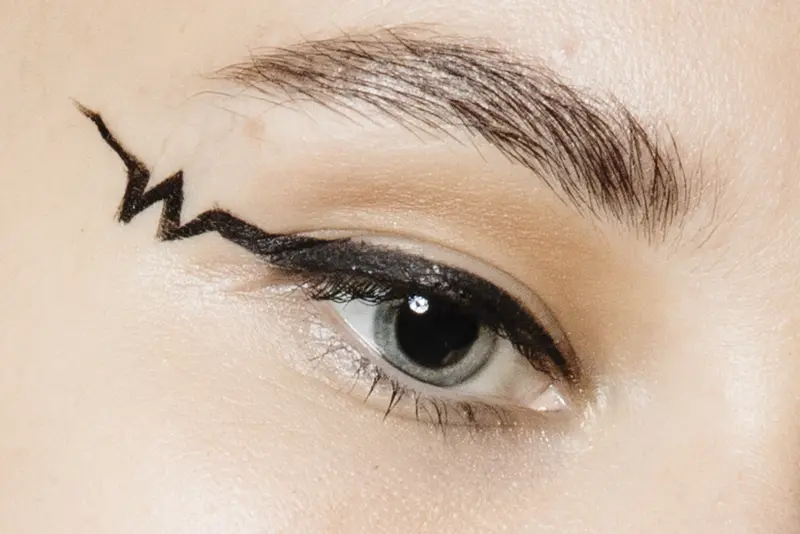 Großaufnahme von einem geschminkten Auge mit grafischem Eyeliner