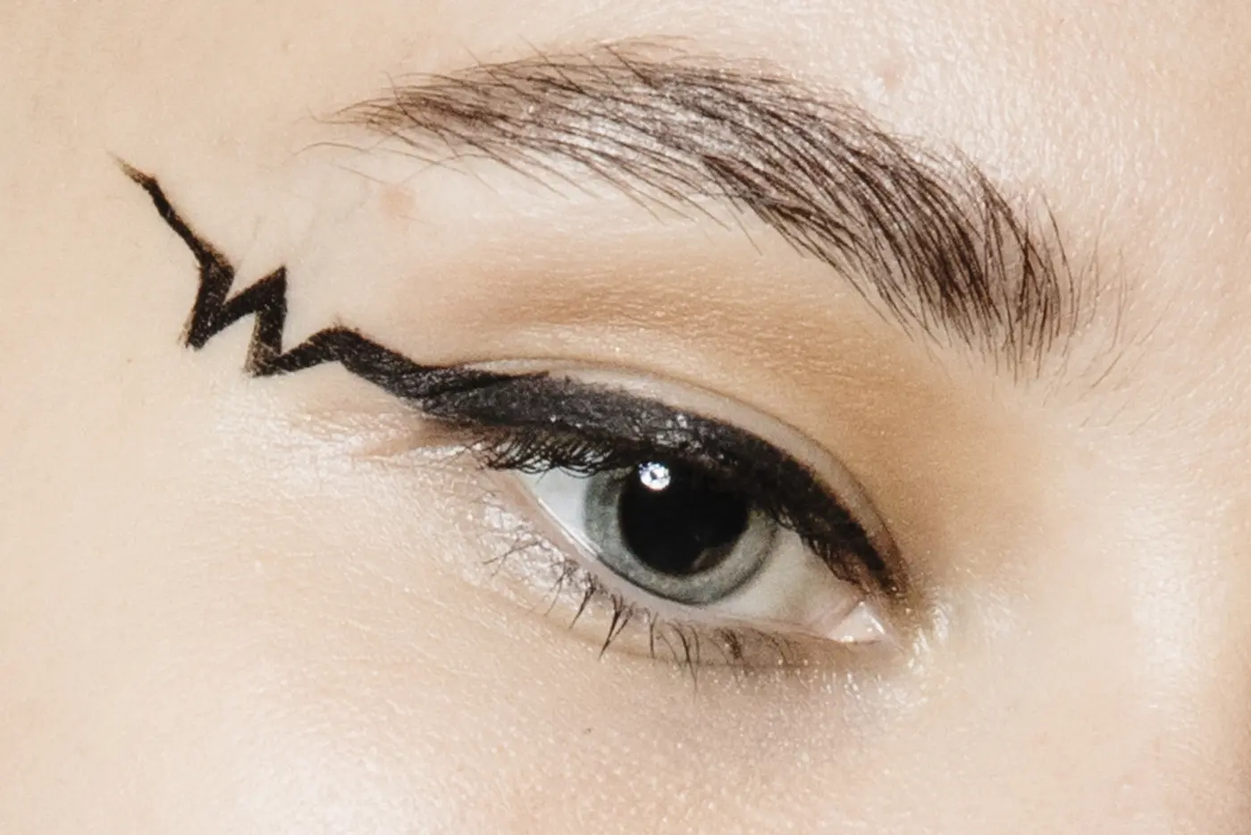 Großaufnahme von einem geschminkten Auge mit grafischem Eyeliner