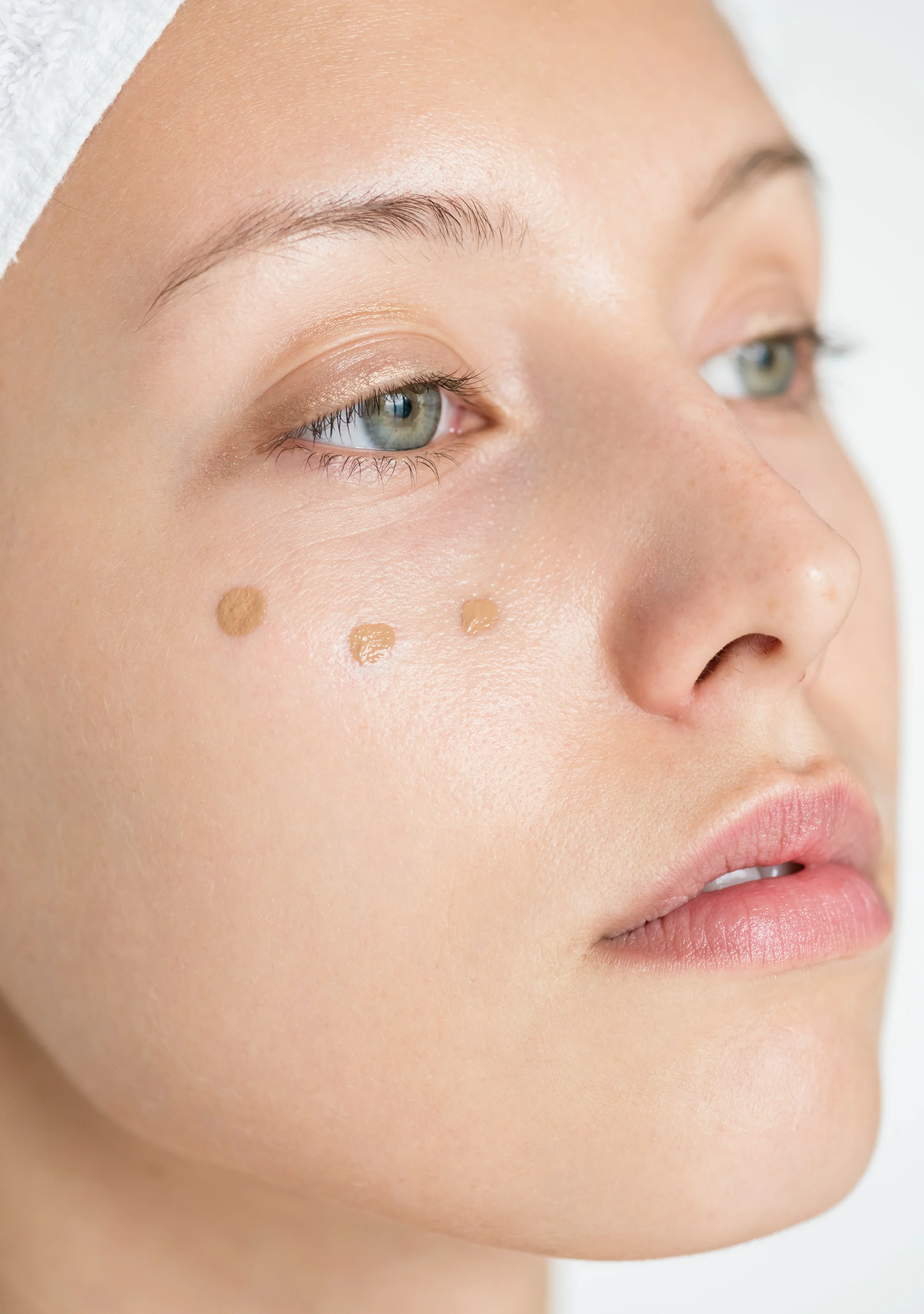 Nahaufnahme Gesicht einer Frau mit Concealer Punkten unter dem Auge