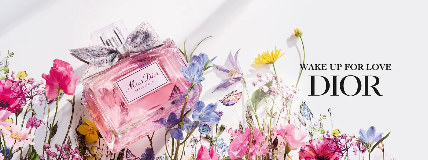 Flakon von Dior Miss Dior Eau de Parfum umgeben von schönen Blumen 