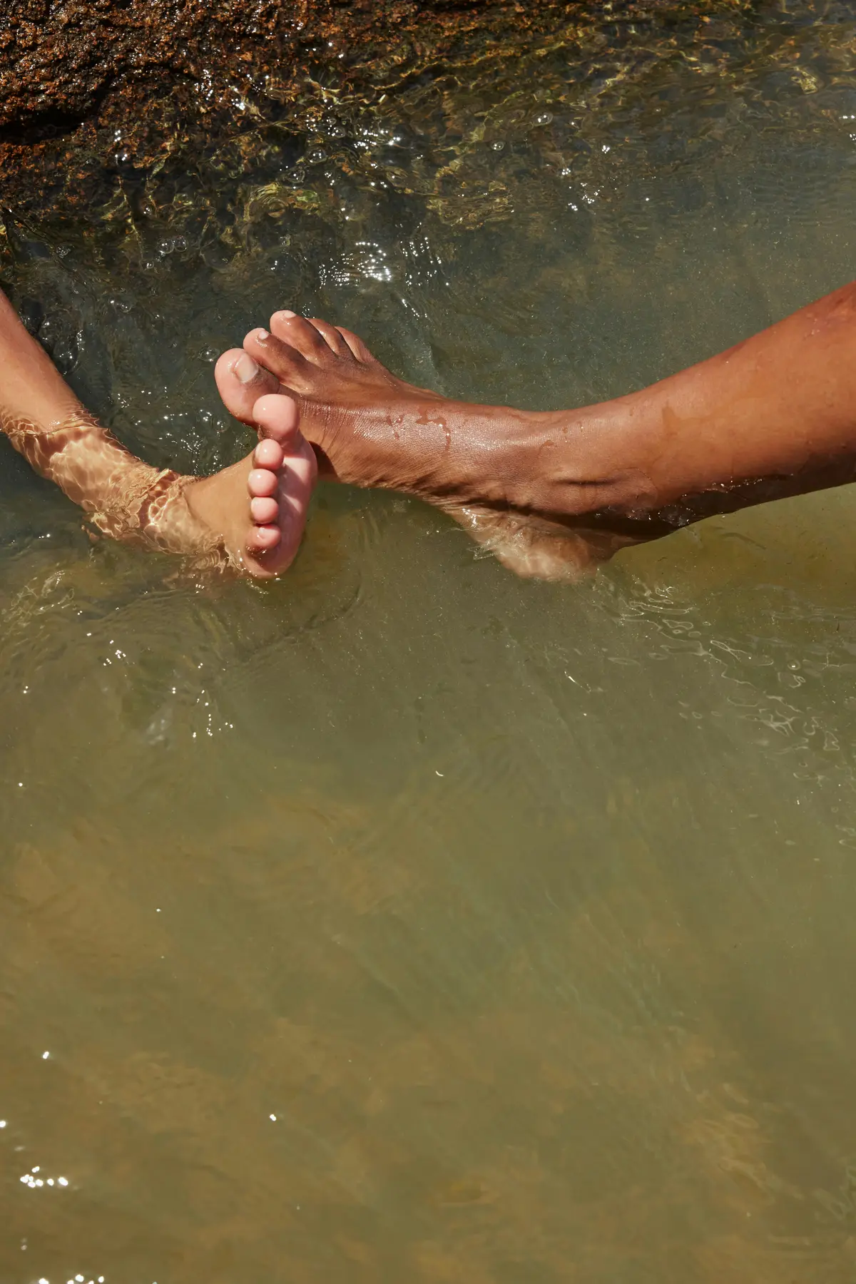 Close-up auf Herren- und Damenfüße im Wasser