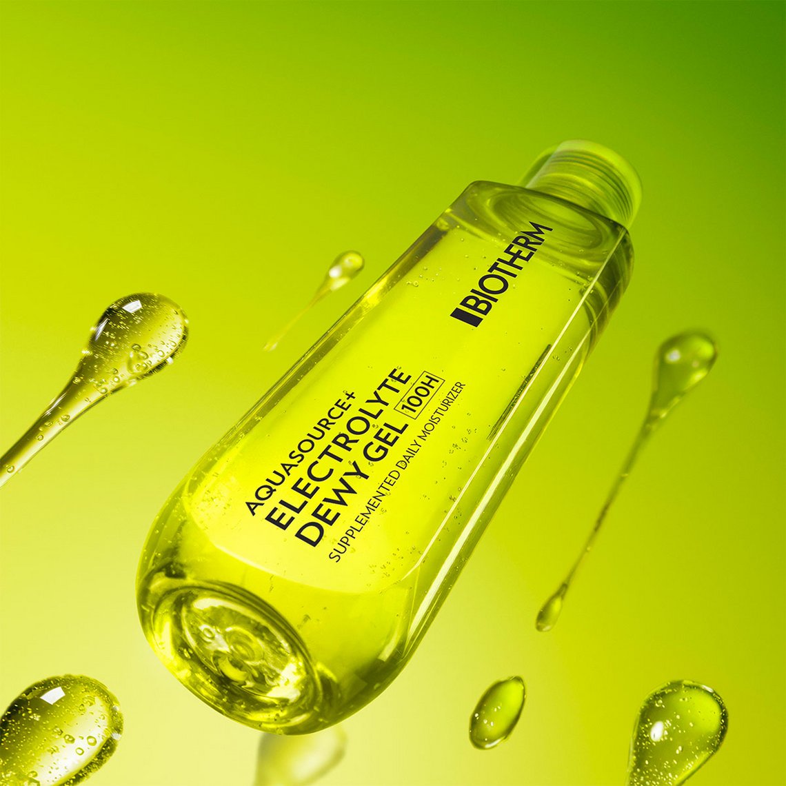 Moodbild des Biotherm Aquasource+ Electrolyte Dewy Gel: transparente, gelbe Gel-Textur in einer schräg liegenden Flasche vor leuchtend grünem Hintergrund, umgeben von schwebenden Gel-Tropfen, die Frische und intensive Feuchtigkeit symbolisieren.