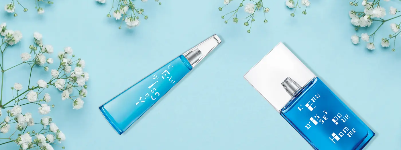 Parfumflacons auf blauem Untergrund mit Blumen verziert
