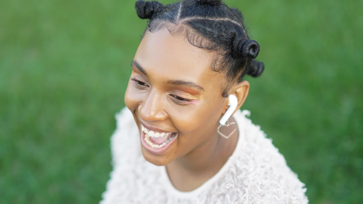 Frau lachend mit Kopfhörern