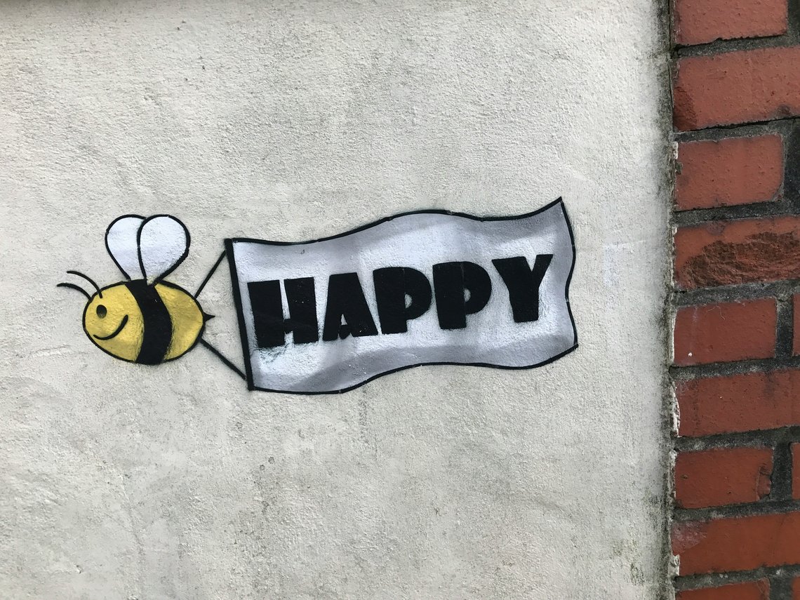 ein-schild-das-sagt-glucklich-mit-einer-biene-darauf