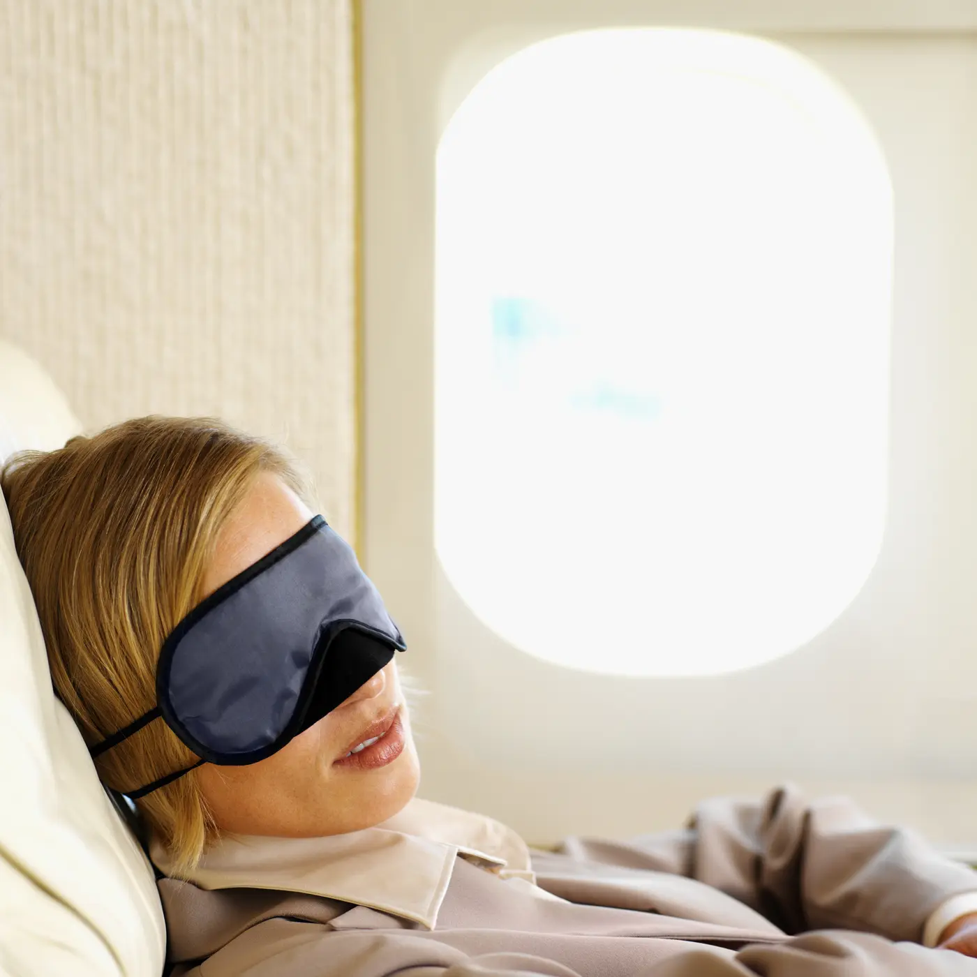 Frau mit Schlafmaske im Flugzeug