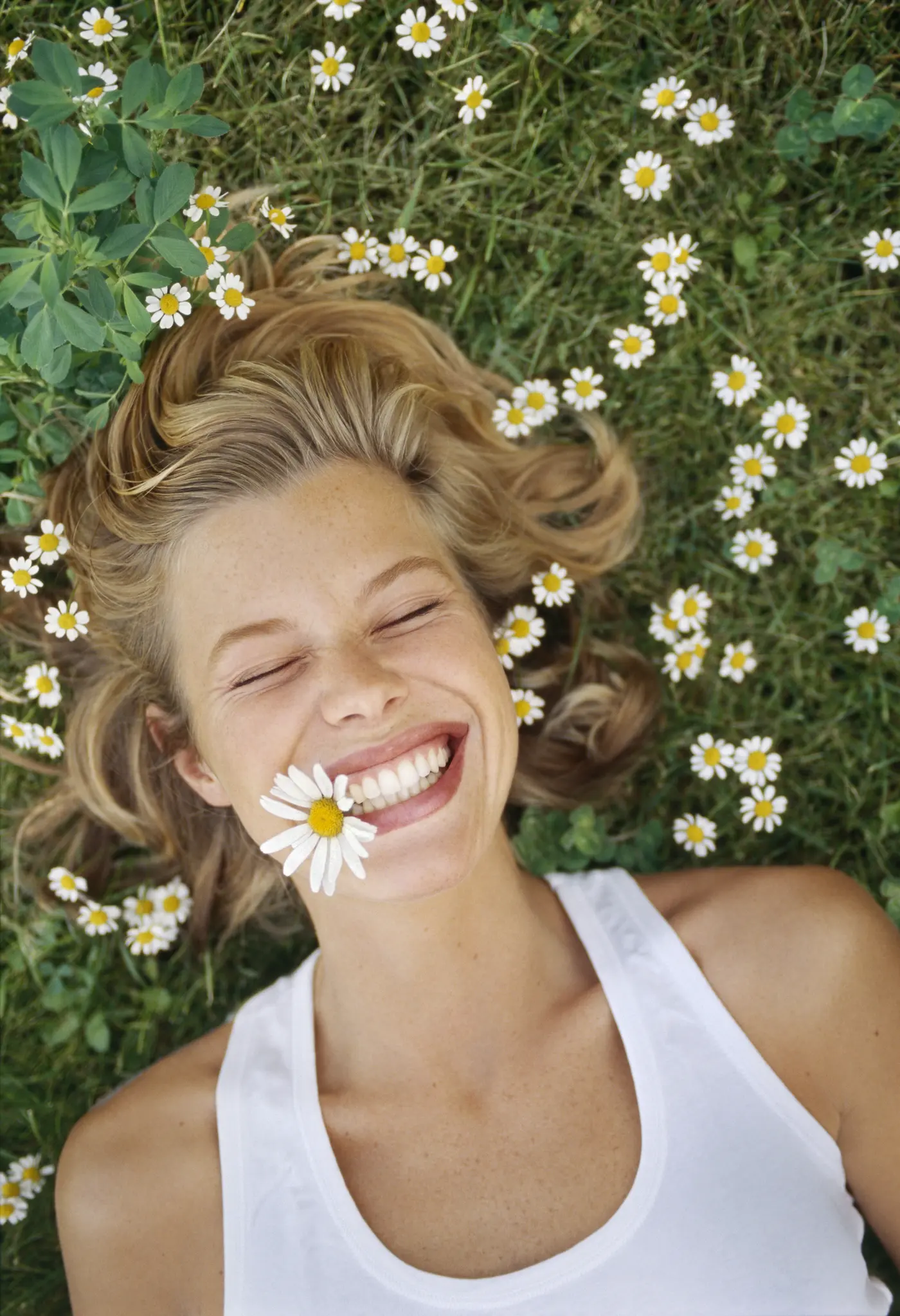 Frau liegt auf Blumenwiese