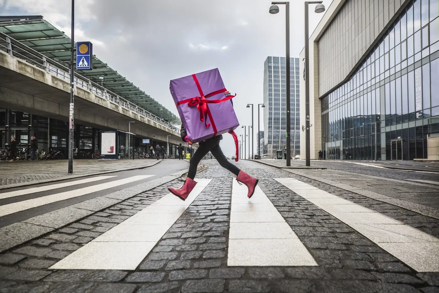 Frau rennt mit Geschenk über die Strasse