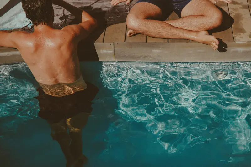 Rückansicht / Detailansicht von Männern, die im Pool baden