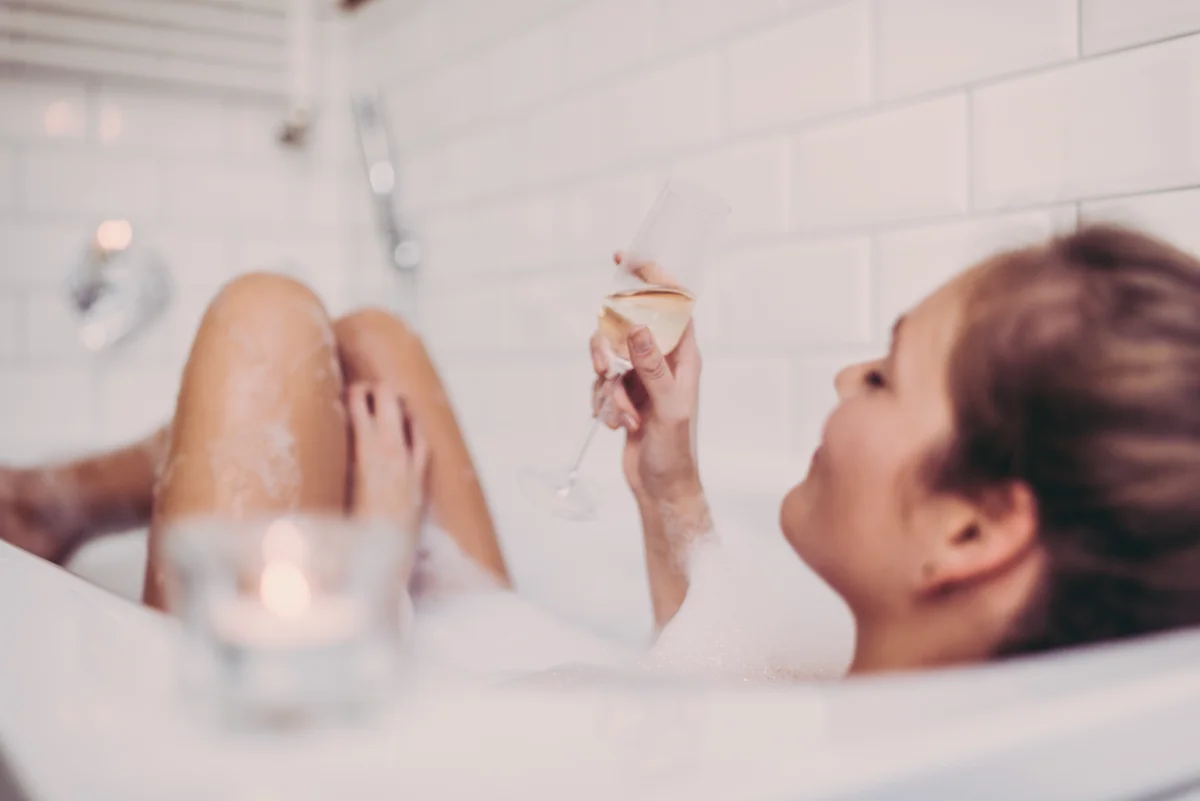 Frau in Badewanne mit Sektglas