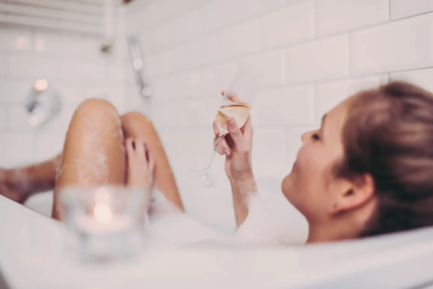 Frau in Badewanne mit Sektglas
