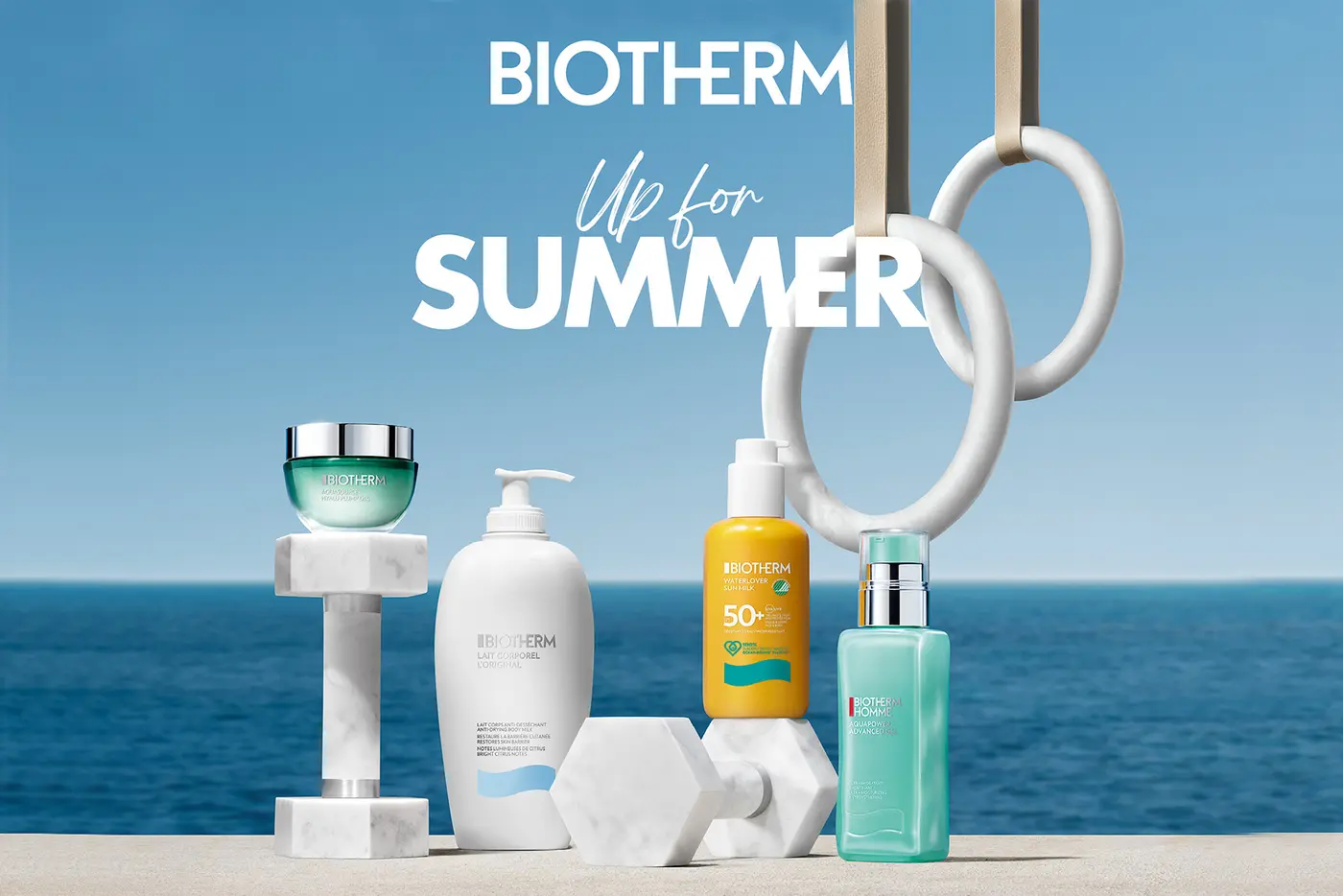 Verschiedene BIOTHERM arrangiert mit Fitnessgeräten, im Hintergrund das Meer