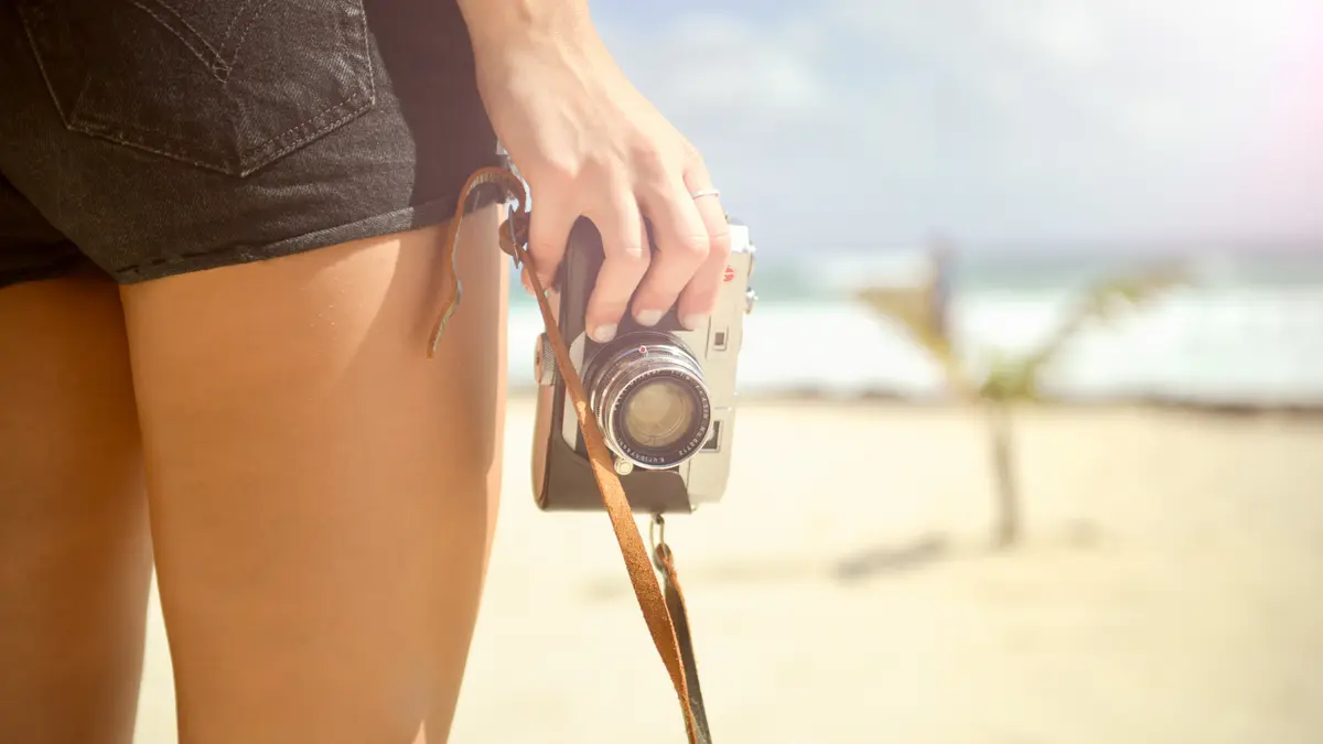 cc0 Bild: Eine Frau in Hotpants hält eine Kamera in der Hand