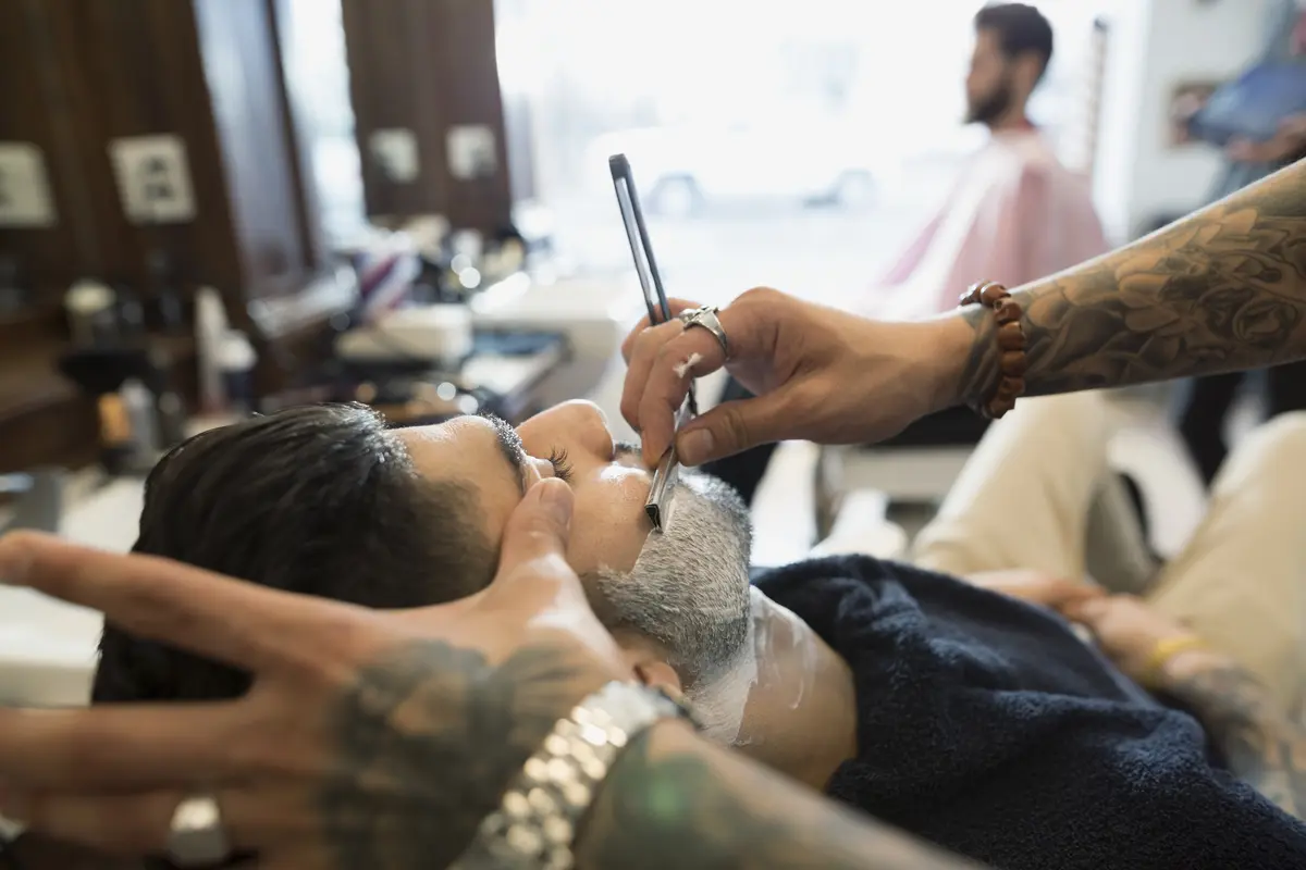 Mann sitzt beim Barbier