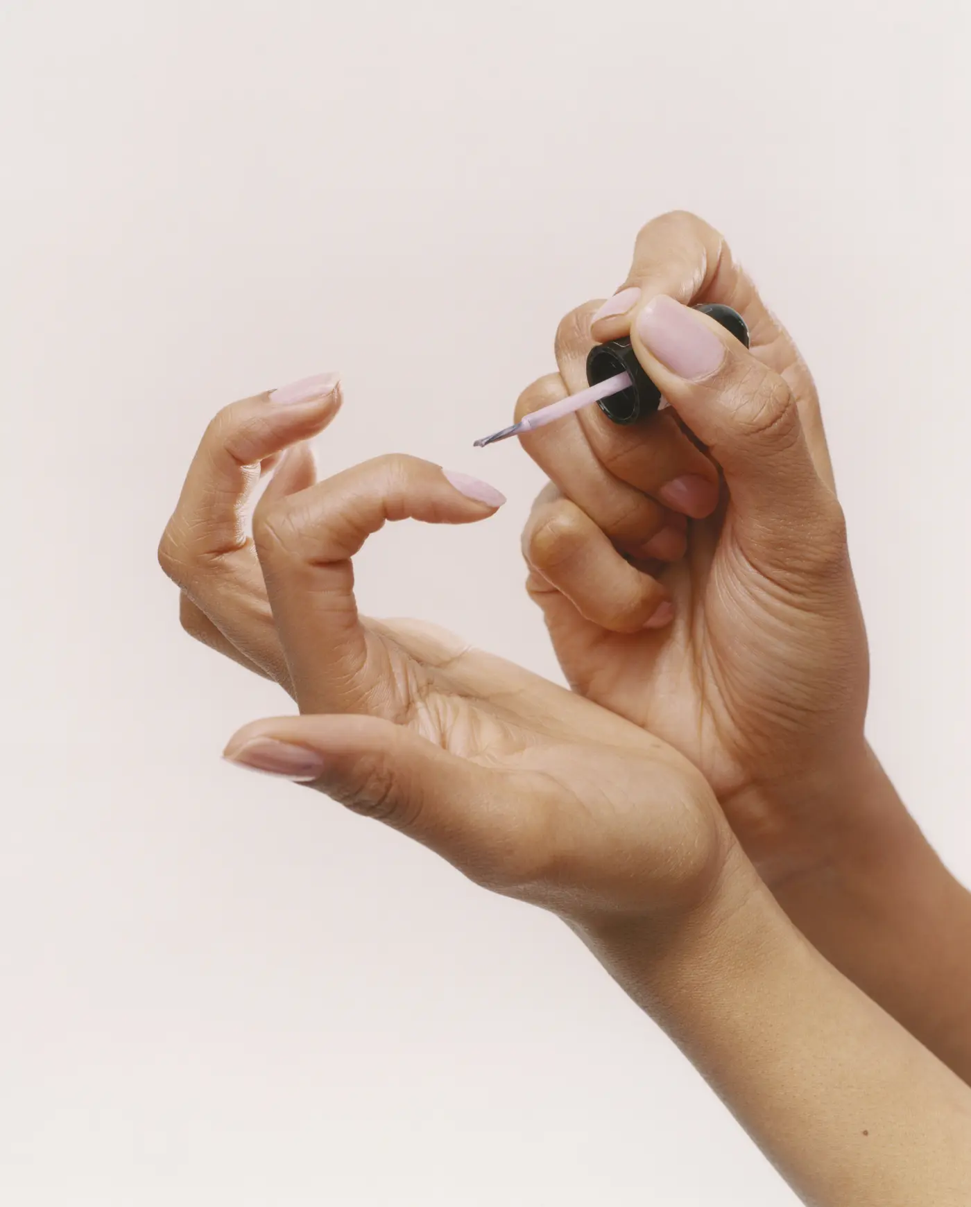 Hände mit Nagellackpinsel