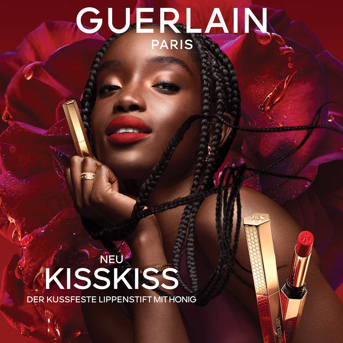 Guerlain KissKiss Werbebanner für den kussfesten Lippenstift mit Honig. Porträt einer Frau mit roten Lippen vor einer großen, dunkelroten Rose, flankiert von den goldenen Lippenstifthülsen.