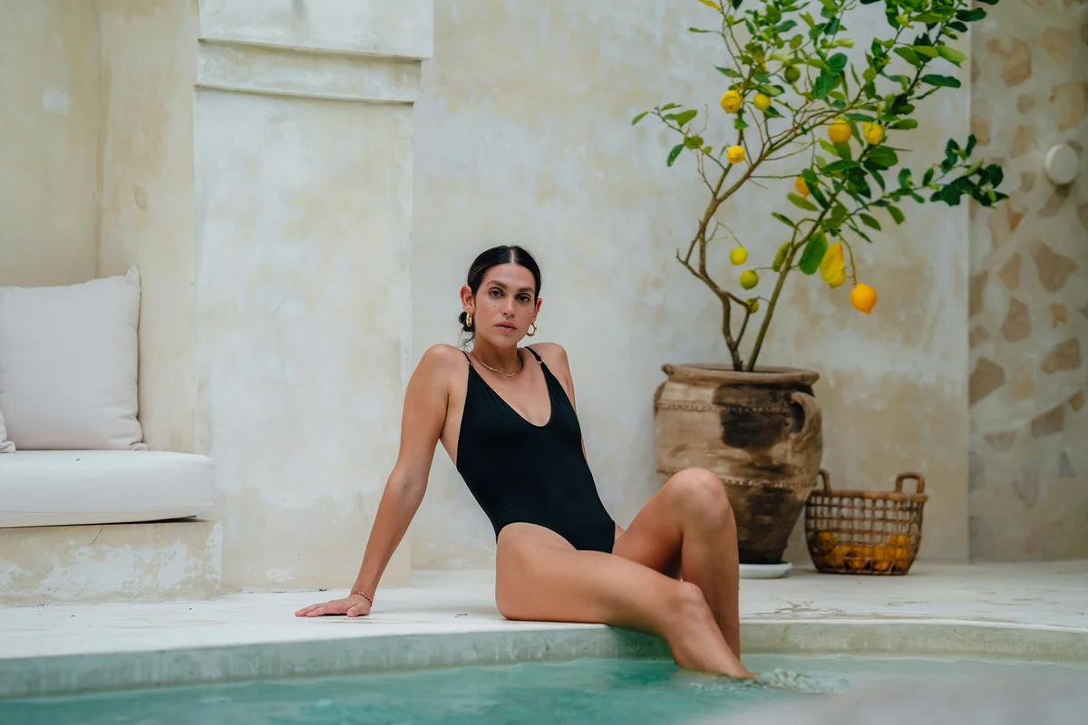 eine-frau-im-badeanzug-sitzt-am-rand-eines-swimmingpools