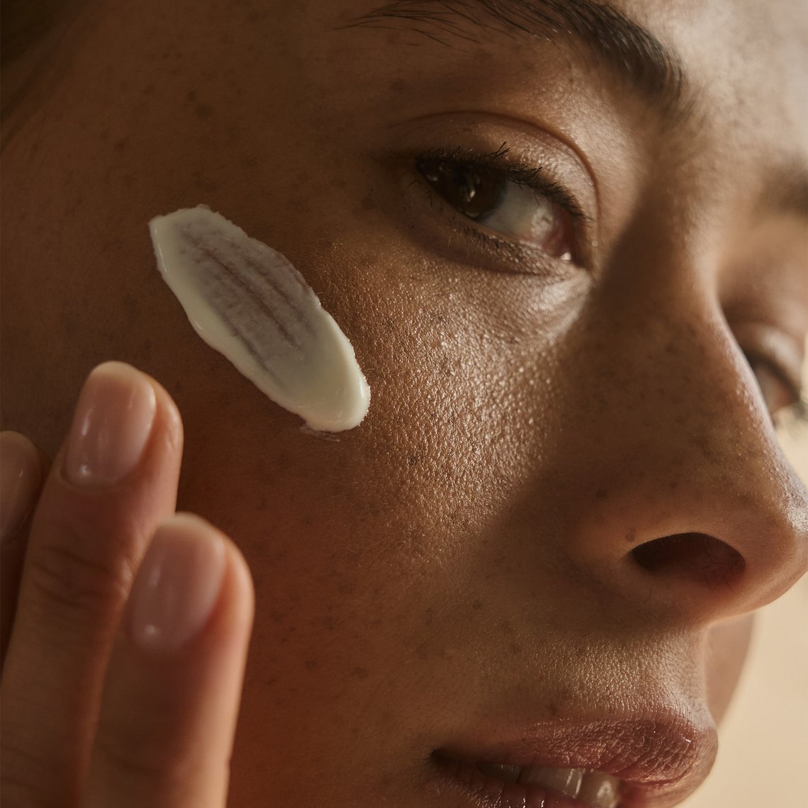 Close-up Frauengesicht: Textur der SILKY BRONZE PROTECTIVE SUNCARE CREAM FOR FACE SPF50+