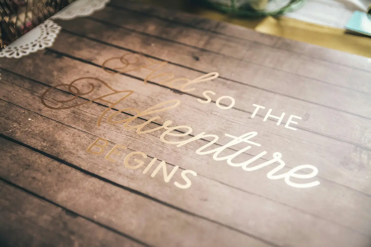 ein-holzernes-schild-auf-dem-steht-so-beginnt-das-abenteuer