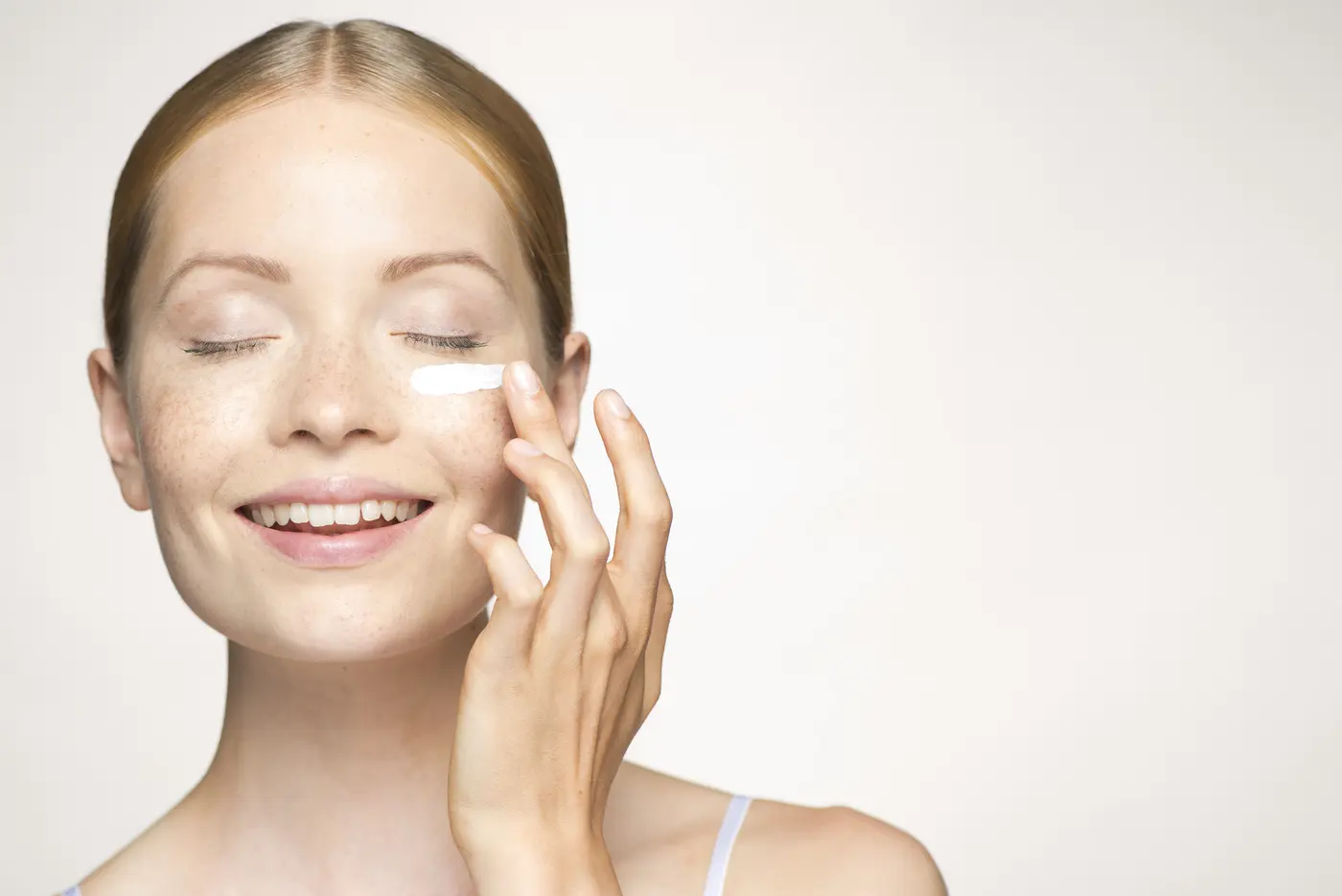 Frau trägt Moisturizer unter dem Auge auf