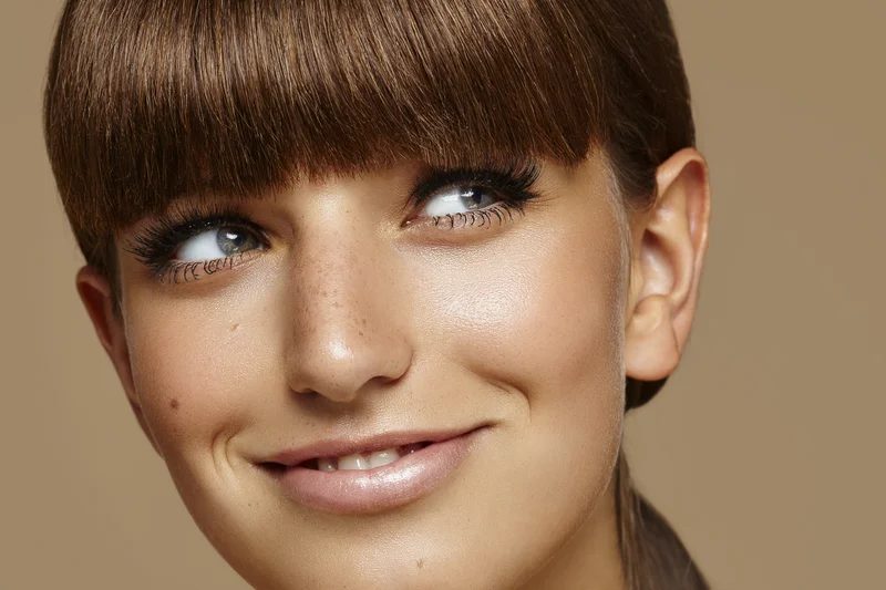 Frau mit schönen Wimpern: Wimpernextensions vs Wimpernserum