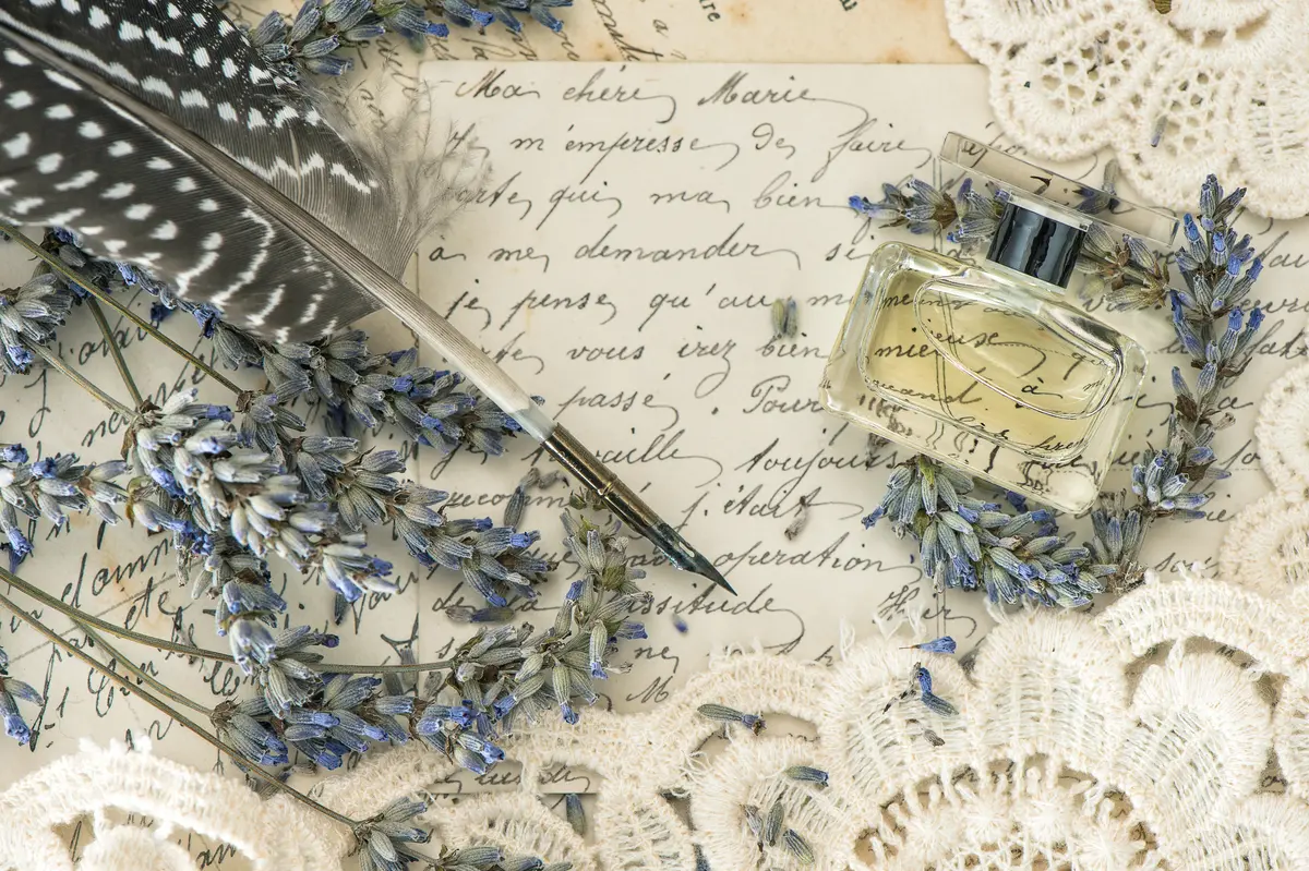 Schreibfeder, Blumen und Parfumflakon