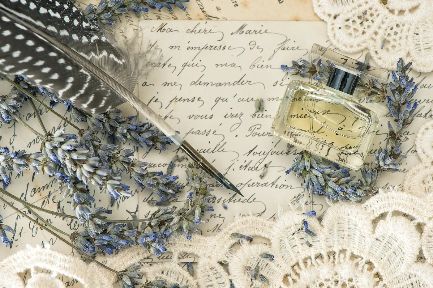 Schreibfeder, Blumen und Parfumflakon