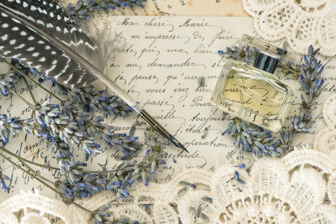 Schreibfeder, Blumen und Parfumflakon