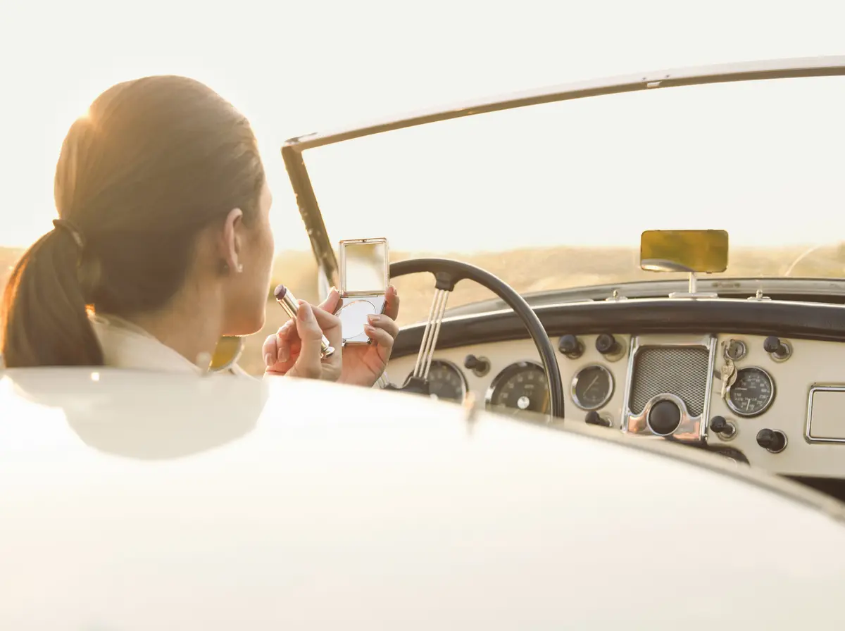 Frau im Cabrio schminkt sich