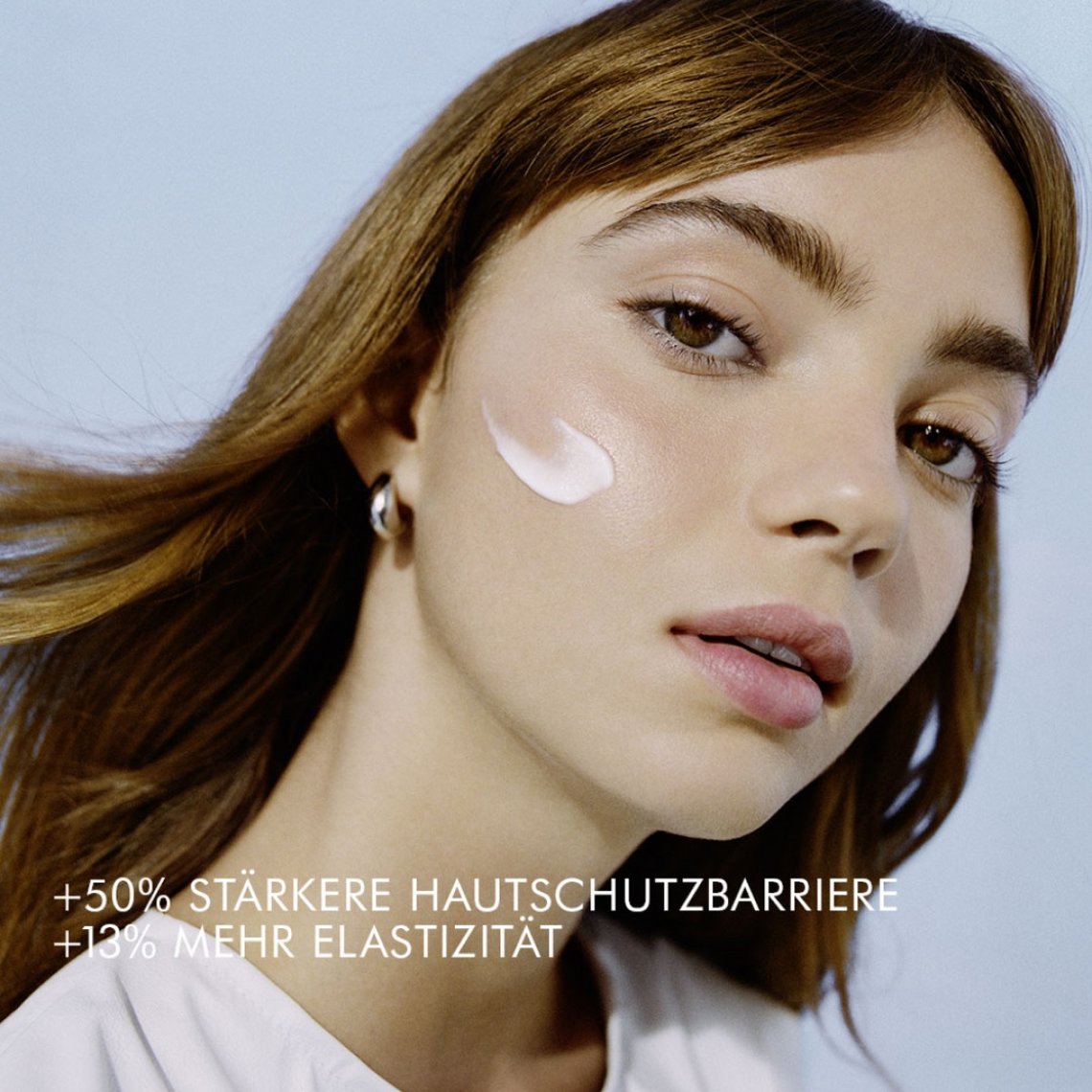 Hübsche, jung aussehende Frau mit Biotherm Cera Repair Barrier Cream im Gesicht