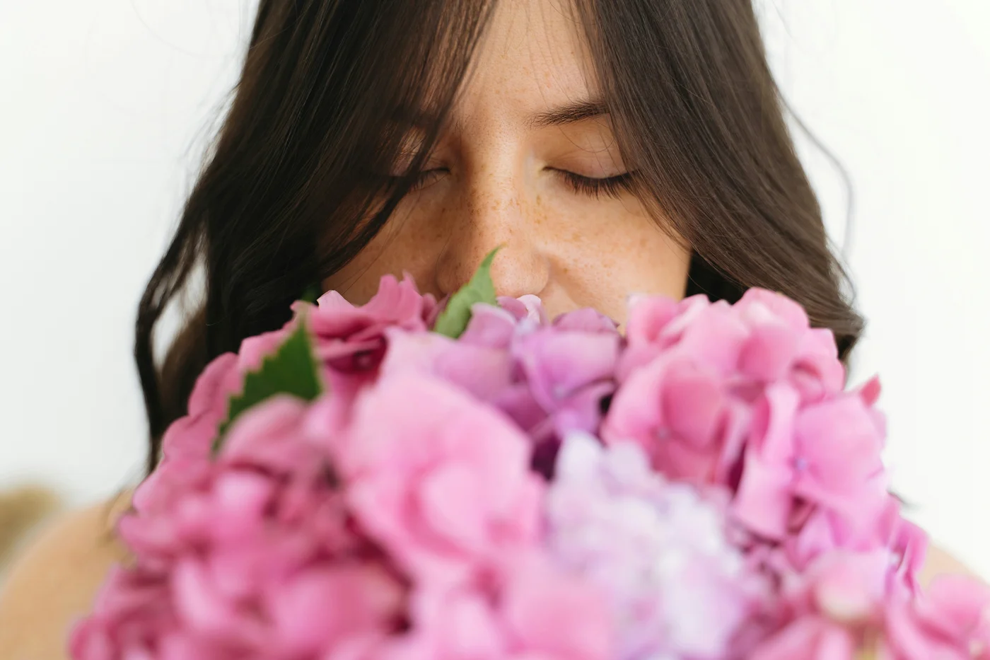 Porträt einer Frau die an einem Blumenstrauß riecht