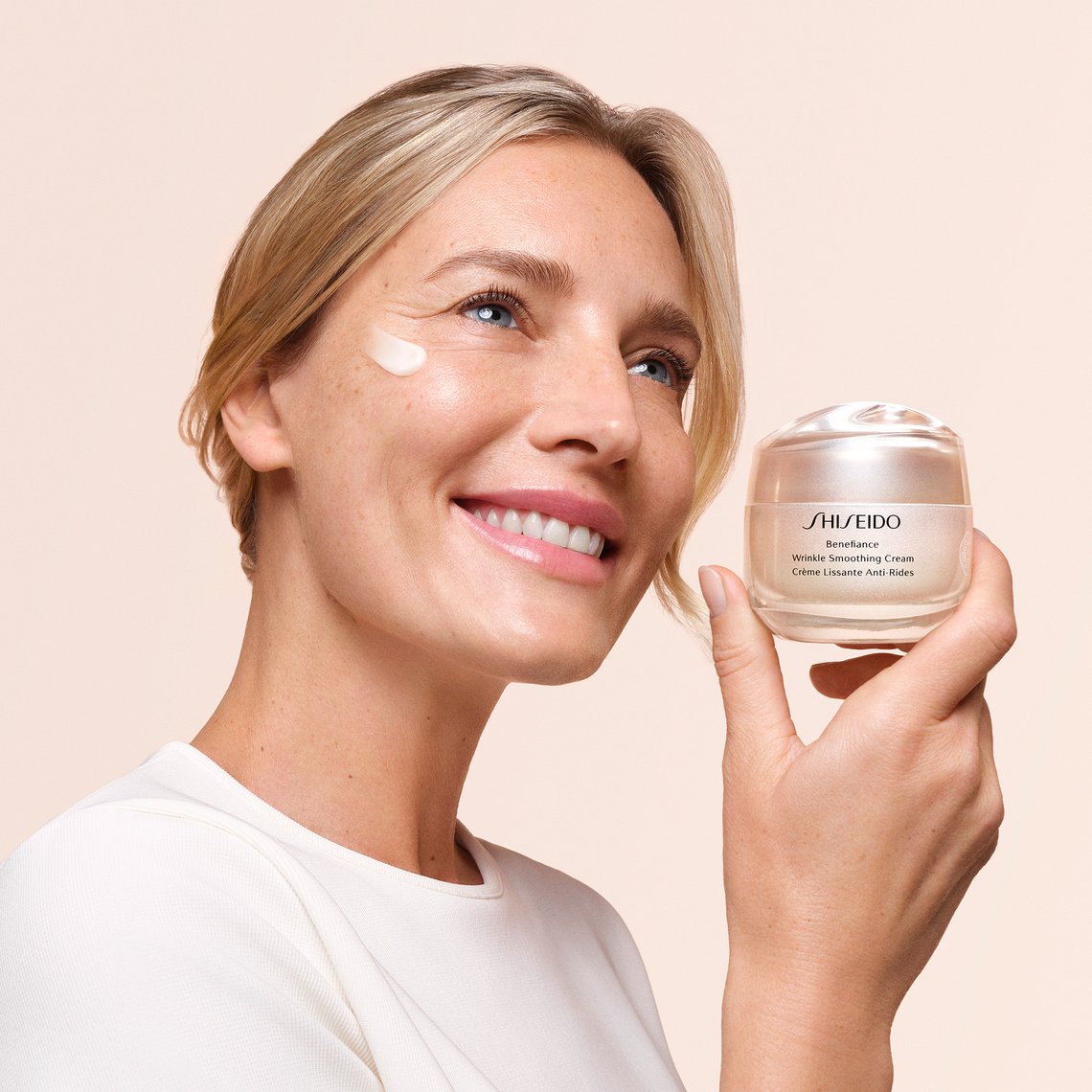 Frau hält Tiegel der Wrinkle Smoothing Cream von Shiseido in der Hand