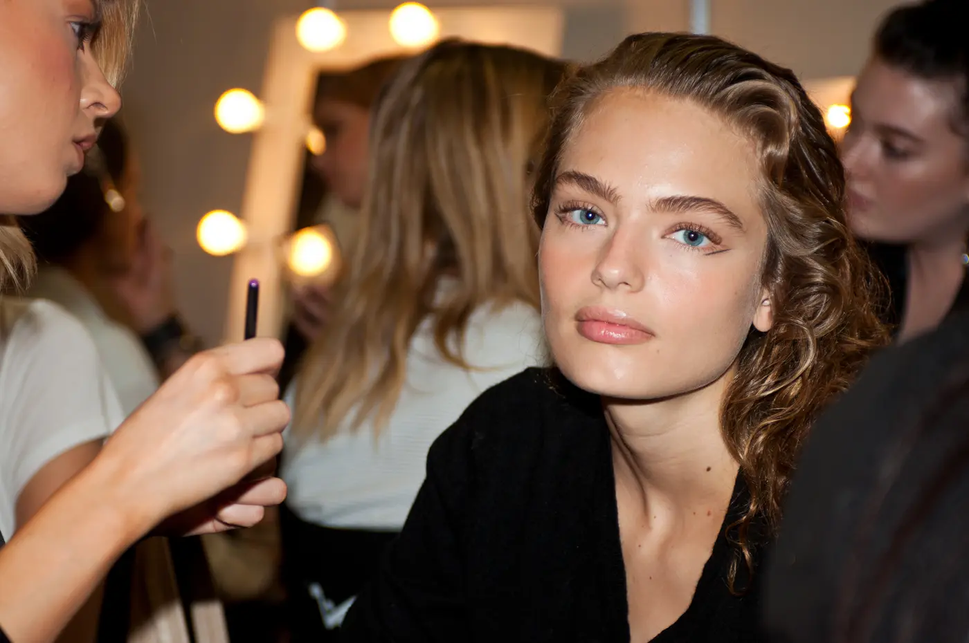 Frau wird auf Fashionweek von Make-up Artist geschminkt